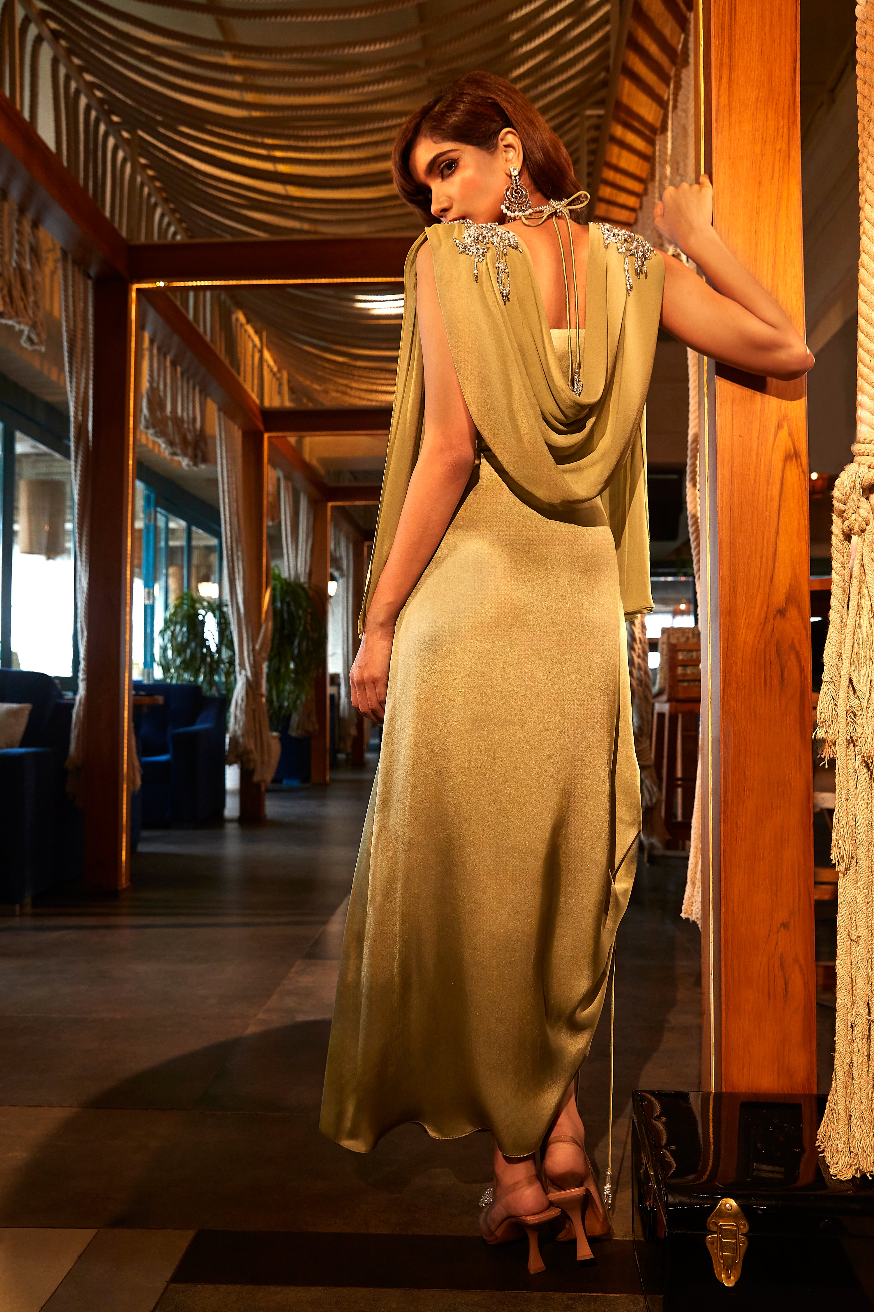 SAGE GREEN DRAPED DRESS TEAMED WITH AN EMBROIDERED CAPE